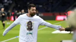 Penyerang Paris Saint-Germain (PSG) Lionel Messi mengenakan kaos dengan potret mendiang legenda sepak bola Brasil Pele sebelum lanjutan Liga Prancis 2022/2023 melawan Angers di Parc des Princes, Kamis (12/1/2023) dini hari WIB. Sebagaimana diketahui, Pele meninggal dunia pada akhir Desember 2022 lalu di usianya yang ke-82 tahun. (AP Photo/Francois Mori)