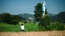 Warga mengamati patung kayu yang menampilkan sosok Melania Trump di pinggiran Sevnica, Slovenia, 5 Juli 2019. Ukiran kayu raksasa tersebut didesain oleh seniman Amerika Serikat, Brade Downey yang kemudian dikerjakan oleh seniman Slovenia, Ales Zupevc menggunakan gergaji mesin. (Jure Makovec/AFP)