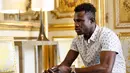 Imigran asal Mali, Mamoudou Gassama saat berbincang dengan Presiden Prancis Emmanuel Macron di Istana Elysee, Paris, Senin (29/5). Selain menawari kewarganegaraan, Macron meminta Gassama bekerja di pemadam kebakaran. (AP Photo/Thibault Camus, Pool)