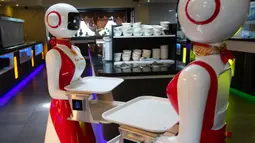 Robot pengganti pelayan sebagai bagian dari uji coba langkah-langkah aturan jaga jarak di restoran keluarga Royal Palace, Belanda, 27 Mei 2020. Robot ini bertugas menyapa pelanggan, menyajikan makanan dan minuman dan mengembalikan alat makan. (AP/Peter Dejong)