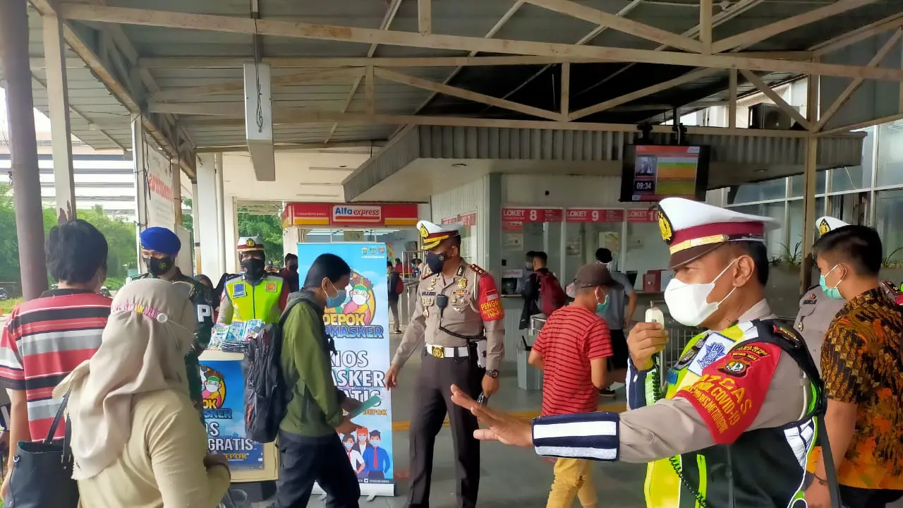 Polrestro Depok Bagi-bagi Masker di Stasiun Depok Baru