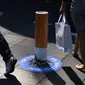 Sejumlah orang hilir mudik di sekitar puntung rokok raksasa di kawasan Pitt Street Mall, Sydney, Australia, Senin (26/9). Puntung rokok raksasa tersebut sebagai kampanye untuk kawasan bebas asap rokok di Sydney. (AFP PHOTO/Saeed Khan)