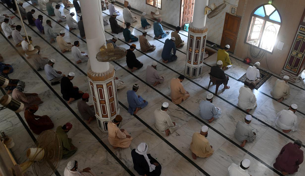 Umat muslim menerapkan jaga jarak aman atau physical distancing saat melaksanakan salat Jumat berjemaah selama Ramadan di sebuah masjid di Karachi, Pakistan, Jumat (1/5/2020). Umat muslim dunia melaksanakan Ramadan tahun ini di tengah pandemi COVID-19. (Asif HASSAN/AFP)