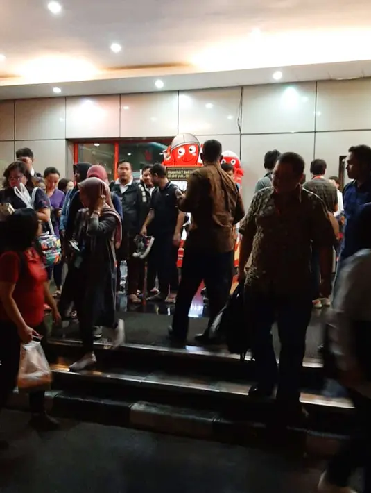 Sejumlah karyawan berkumpul di luar gedung perkantoran setelah merasakan gempa di Serpong, Tangerang pada Jumat (2/8/2019). Data dari BMKG, gempa dengan kekuatan magnitudo 7,4 mengguncang hingga Jakarta dan sekitarnya dengan pusat gempa berada di 147 km Barat Daya Sumur, Banten. (INDARYANI/AFP)