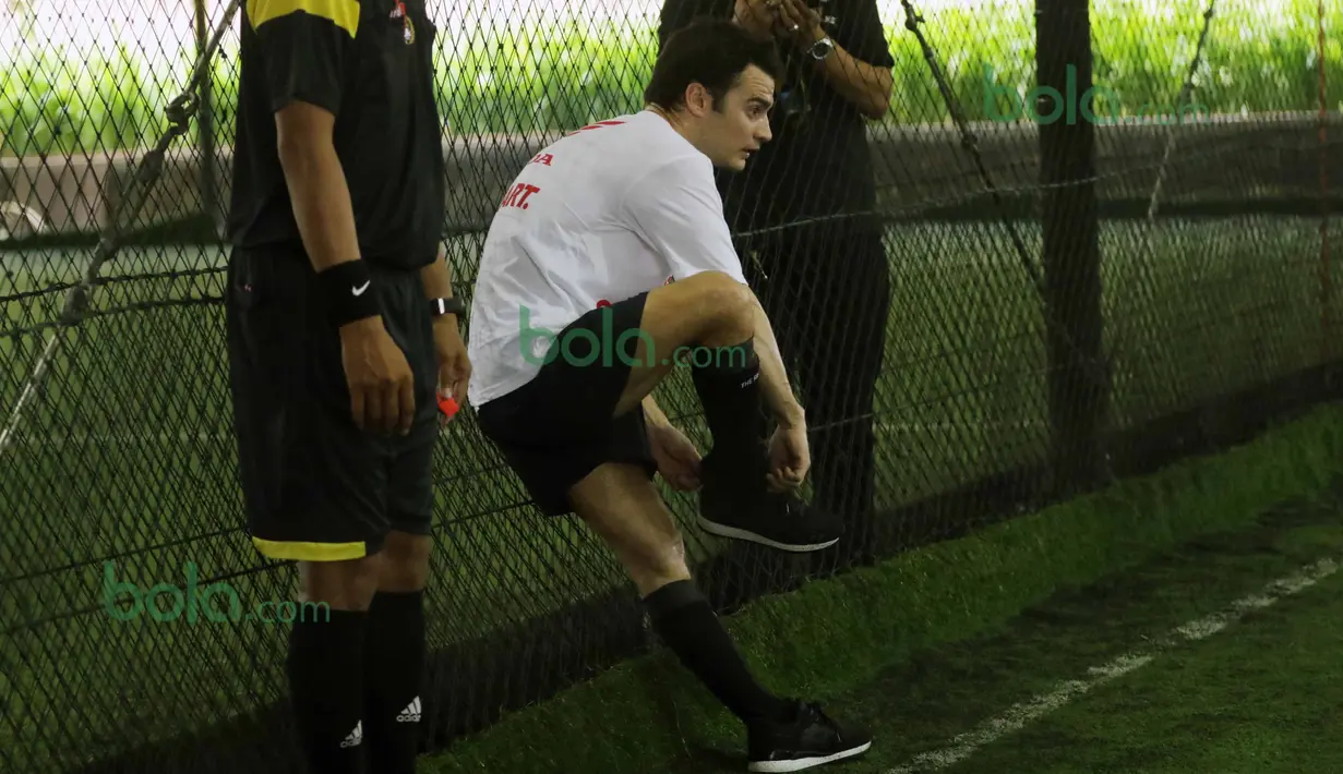 Dani Pedrosa memakai sepatunya yang copot saat bermain futsal di Lapangan Futsal Kuningan Village, Jakarta, Sabtu (13/2/2016). (Bola.com/Nicklas Hanoatubun)
