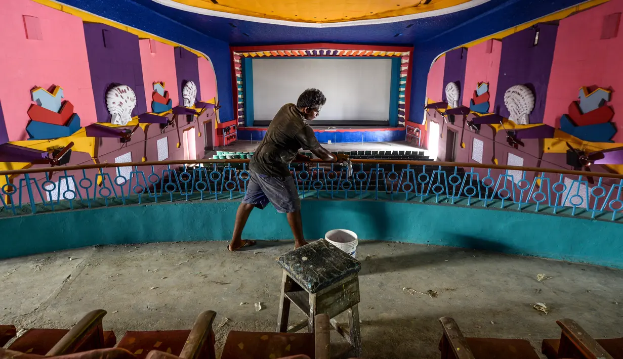 Pekerja membersihkan ruang bioskop sebagai persiapan kemungkinan pembukaan kembali setelah pelonggaran pembatasan Covid-19, di Chennai, Sabtu (3/10/2020). Kementerian Kesehatan India melaporkan pada Sabtu (3/10) total kematian di India akibat virus corona naik menjadi 100,842. (Arun SANKAR/AFP)
