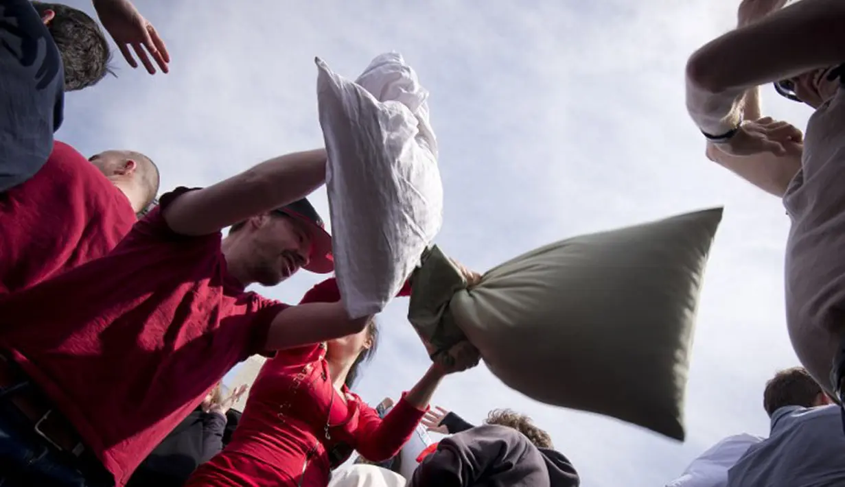 Meskipun saling serang dengan bantal. Para peserta tidak marah. Justru mereka terlihat bahagia (AFP PHOTO / BEN STANSALL).