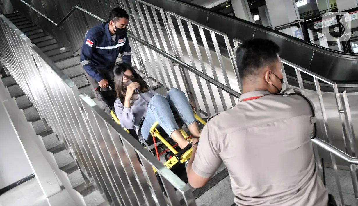 Petugas Light Rail Transit (LRT) Jakarta membantu penumpang disabilitas turun dari tangga di Stasiun Pegangsaan Dua, Jakarta Utara, Selasa (24/1/2023). Melalui kampanye #NyamankanJakarta, LRT Jakarta ingin mewujudkan pelayanan transportasi publik yang prima dengan menumbuhkan rasa aman, nyaman, dan ramah lingkungan bagi para pengguna. (merdeka.com/Iqbal S. Nugroho)
