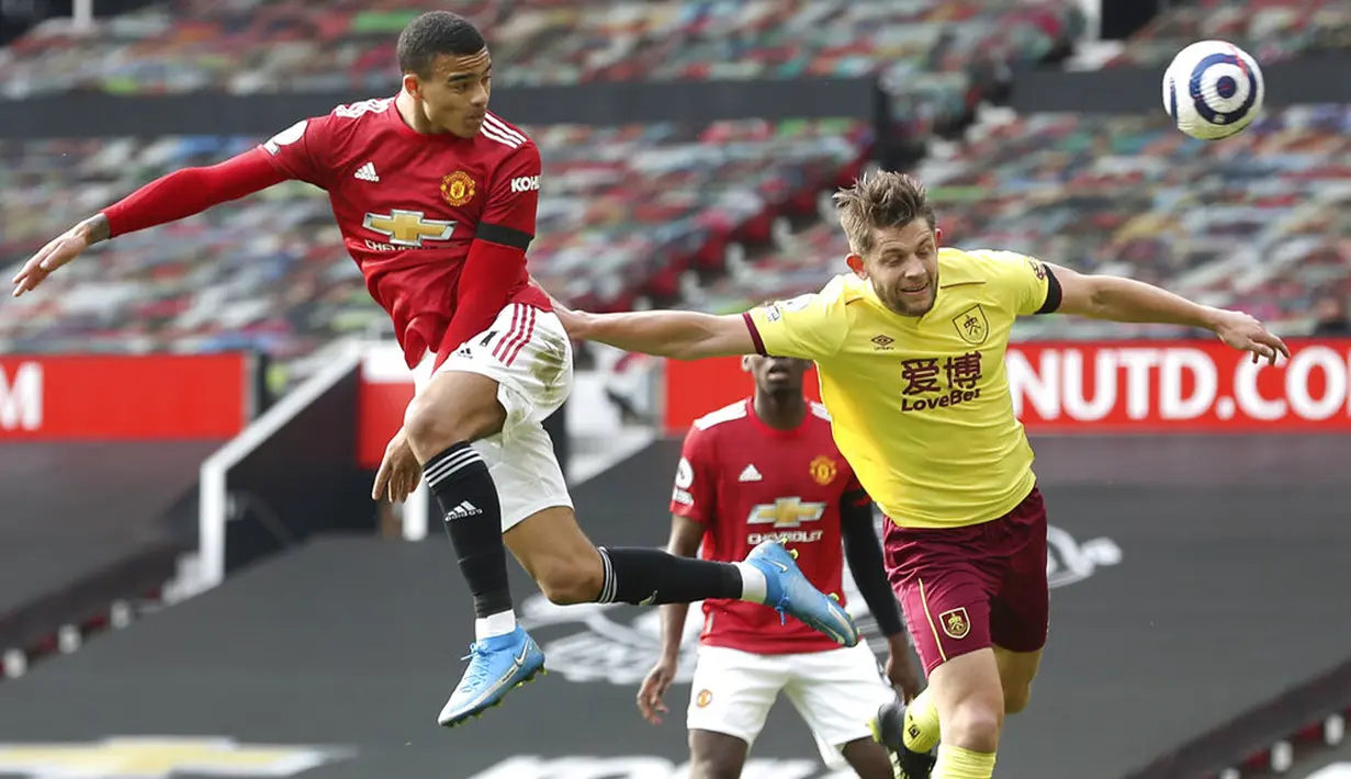 Pemain Manchester United Mason Greenwood (kiri) berusaha mencetak gol ke gawang Burnley pada pertandingan Liga Inggris di Stadion Old Trafford, Manchester, Inggris, Minggu (18/4/2021). Manchester United menang 3-1. (Martin Rickett/Pool via AP)