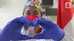 Vaksinator menunjukkan vaksin COVID-19 dosis ketiga atau booster untuk tenaga kesehatan di RSUD Matraman, Jakarta, Jumat (6/8/2021). Pemberian vaksin dosis ketiga atau booster kepada tenaga kesehatan di Indonesia ditargetkan rampung pada pekan kedua Agustus 2021. (Liputan6.com/Herman Zakharia)