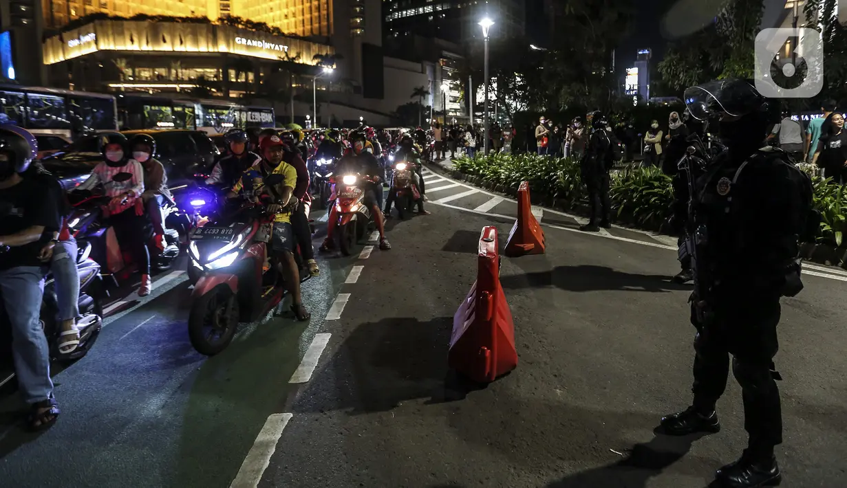 Suasana mobilitas warga saat perayaan malam Tahun Baru di Jakarta, Jumat (31/12/2021). Polda Metro Jaya melakukan pengendalian mobilitas Crowd Free Night (malam bebas keramaian) dengan membubarkan warga yang nekat keluar rumah dan tidak mematuhi aturan. (Liputan6.com/Johan Tallo)
