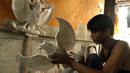 Perajin menyelesaikan pembuatan patung Garuda Pancasila yang terbuat dari serat kaca (fiberglas) di kawasan Kalimalang, Jakarta Timur, Selasa (16/8/2022). Jelang HUT Kemerdekaan RI, permintaan patung Garuda Pancasila meningkat hingga 80 persen. (merdeka.com/Arie Basuki)