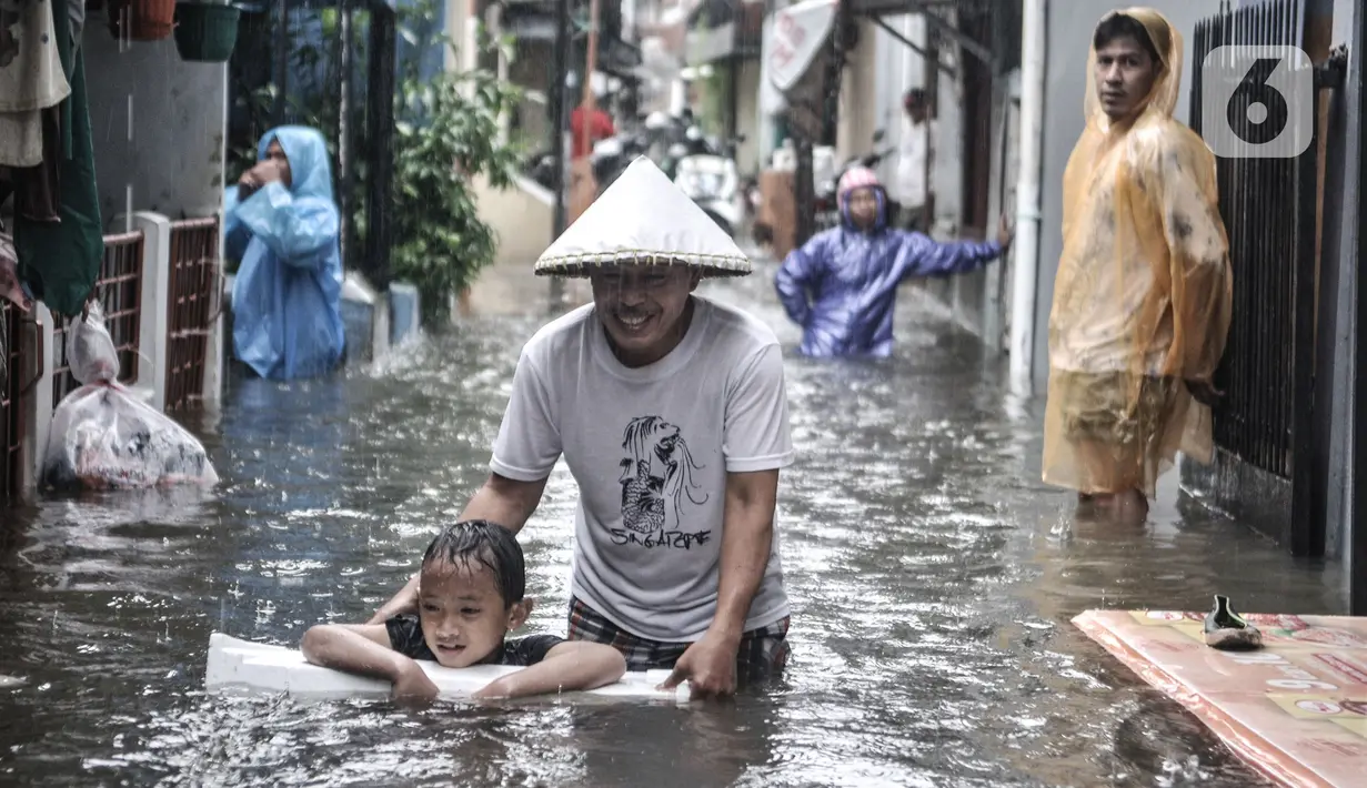 Aktivitas warga saat banjir merendam permukiman di Bukit Duri, Jakarta, Kamis (18/2/2021). Hujan deras yang mengguyur sejak pagi menyebabkan permukiman warga di 5 RW, yakni RW 03, 04, 05, 06, dan 07 Kelurahan Bukit Duri terendam banjir. (merdeka.com/Iqbal S Nugroho)