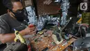 Animator Toto Sihono, membuat produk berupa pajangan dari limbah komponen elektronik di Galeri Artos Griya Asri Pamulang, Tangerang Selatan, Rabu (16/8/2020). Produk dari limbah elektronik yang digeluti sejak tahun 2016 dijual dengan harga Rp250 - 350 ribu perbuah. (Liputan6.com/Fery Pradolo)