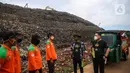 Direktur PT Bima Karya Prima Jeffry Riadi (kanan) dan Musisi serta Penggiat Lingkungan Hidup Nugie (kedua kanan) berbincang dengan pasukan orange saat peringatan Hari Sampah Nasional di TPST Bantar Gebang, Bekasi, Senin (21/2/2022). (Liputan6.com/JohanTallo)