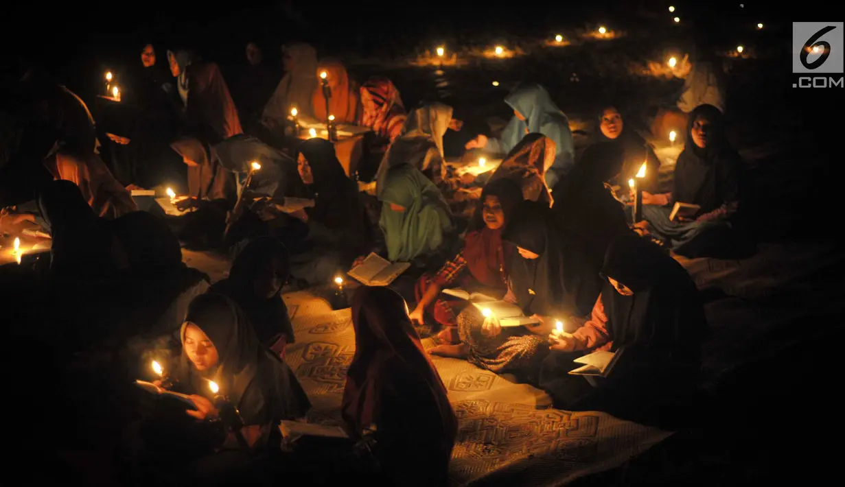 Santri dari Pondok Pesantren  Nurul Hidayah melakukan tadarus alquran dengan penerangan obor di tengah sawah Dusun Tempel, Desa Sempu, Kecamatan Andong, Kabupaten Boyolali, Selasa ( 21/5/2019). Pengajian tersebut untuk menyambut malam Nuzulul Quran pada 17 Ramadan 1440 Hijriah. (Liputan6.com/Gholib)