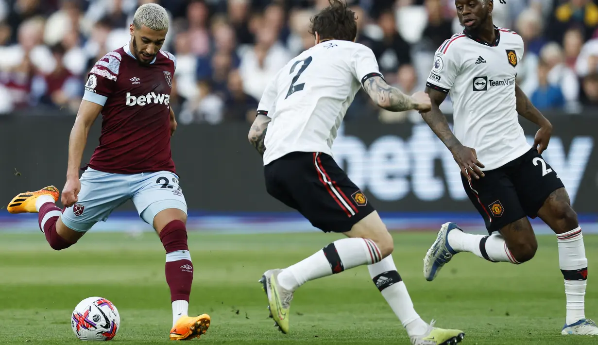 Pemain West Ham United, Said Benrahma (kiri), menendang bola ke gawang MU dan membuahkan gol dalam laga pekan ke-35 Premier League 2022/2023 yang berlangsung di London Stadium, Senin (8/5/2023) dini hari. (AFP/Ian Kington)