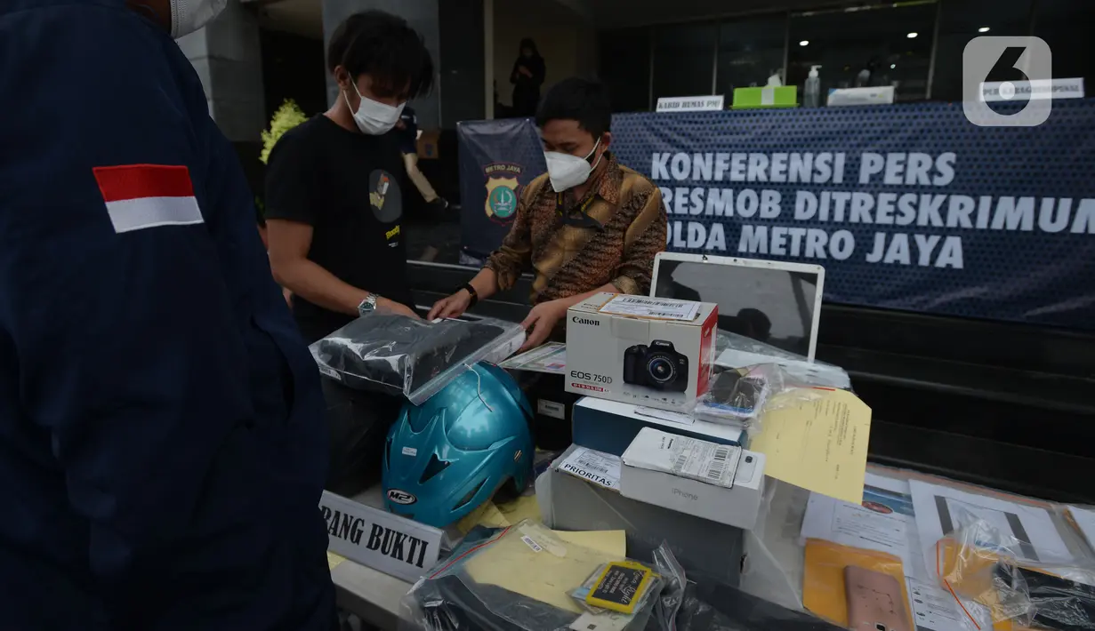 Petugas menata barang bukti dalam rilis tindak pidana pemalsuan surat hasil tes PCR dan swab antigen di Polda Metro Jaya, Selasa (13/7/2021). Petugas mengamankan barang bukti dokumen pembuatan surat swab antigen dan PCR palsu dengan tarif Rp170 - Rp 300 ribu. (merdeka.com/Imam Buhori)