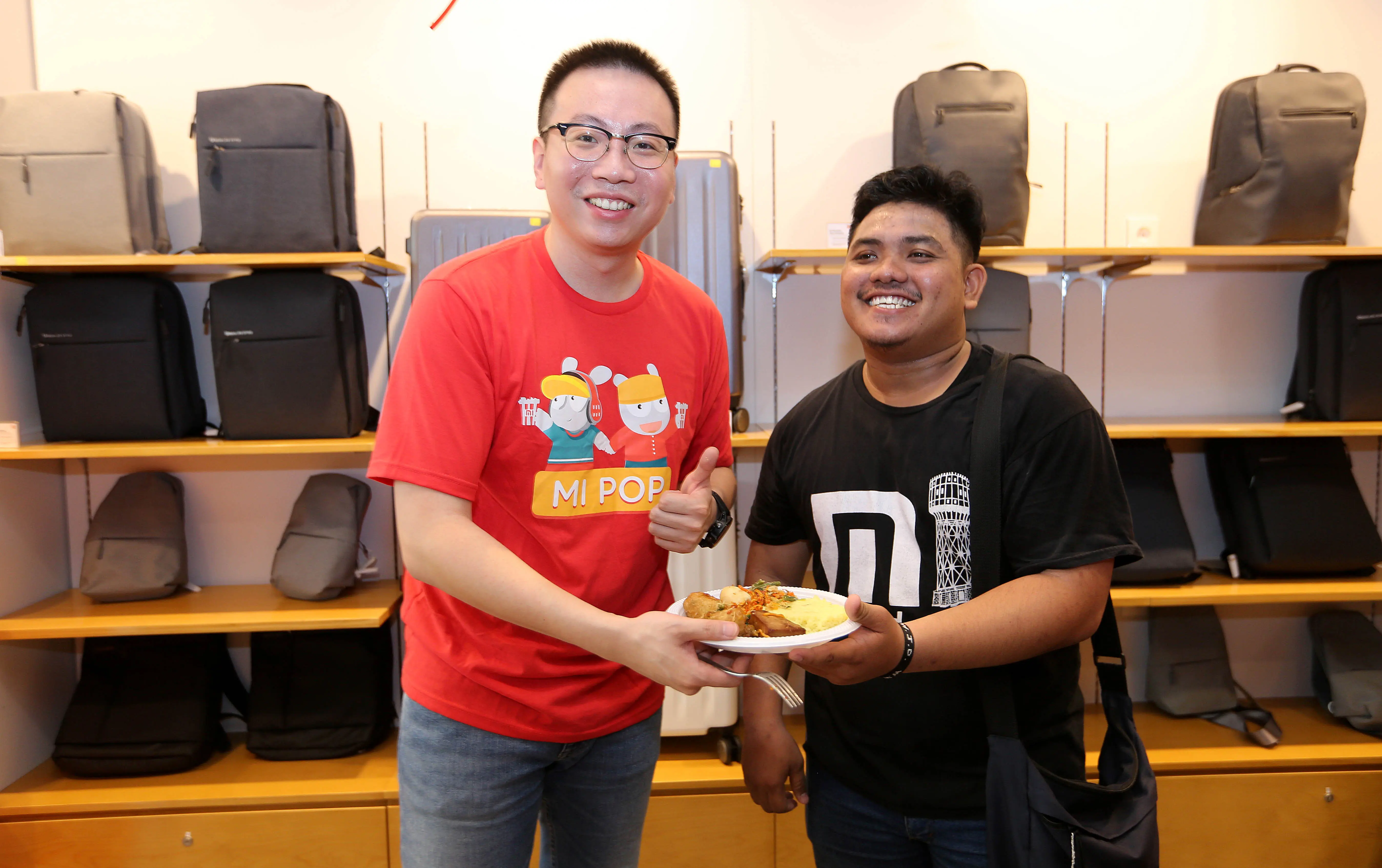 Steven Shi, Head of Xiaomi South Pacific Region and Xiaomi Indonesia Country Manager, memberikan potongan nasi tumpeng kepada para pelanggan serta Mi Fans yang hadir (Foto: Xiaomi Indonesia)