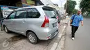 Seorang warga melintas di samping mobil yang diparkir di atas trotoar Jalan Juanda, Bekasi, 4 Oktober 2016. Padahal fungsi trotoar sejatinya merupakan hak pejalan kaki sesuai dengan UU No 2 Tahun 2009 Tentang Lalu Lintas dan Angkutan Jalan. (Foto: Fajar)