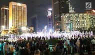 Warga menikmati car free night saat malam pergantian tahun di kawasan Bundaran HI, Jakarta, Senin (31/12). Hujan yang mengguyur Jakarta sejak siang tidak menyurutkan antusias warga menikmati&nbsp;car free night. (Liputan6.com/Angga Yuniar)