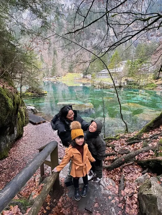 Dengan latar pemandangan danau yang sangat indah, Rachel Vennya berpose bersama kedua anaknya mengenakan puffer jacket berwarna hitam. [Foto: Instagram/rachelvennya]