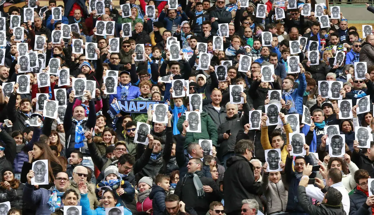 Wajah Kalidou Koulibaly  memenuhi stadion saat Suporter Napoli memberi dukungan sebelum laga  Serie A Liga Italia di San Paolo stadium, Minggu (7/2/2016).  Kalidou mendapat dukungan atas tindakan rasis dari fans Lazio. (AFP/Carlo Hermann)