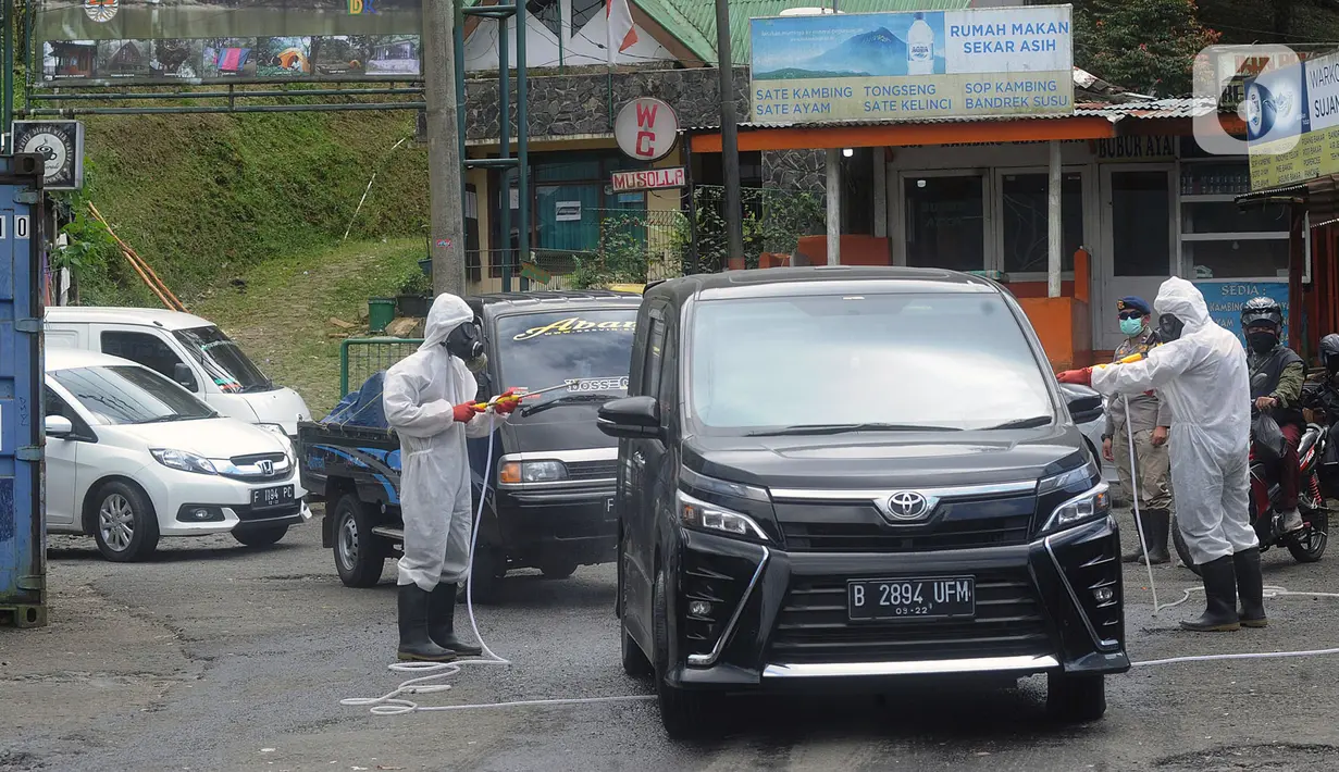 Anggota Batalyon B Brimob Cipanas melakukan penyemprotan disinfektan saat penyekatan arus lalu lintas di kawasan Ciloto, Cianjur, Jawa Barat, Jumat (17/4/2020). Penyemprotan yang dilakukan selama 20 hari tanpa henti ini untuk mencegah penyebaran virus corona COVID-19. (merdeka.com/Arie Basuki)