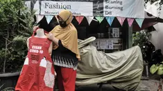 Siti Zahro (44) memajang celemek berbahan tas bansos Covid-19 buatannya di depan industri jahit rumahan KG-Lupe Fashion, Salemba, Jakarta, Senin (16/11/2020). Inovasi Siti bermula dari sepinya pesanan jahit akibat pandemi. (merdeka.com/Iqbal S. Nugroho)