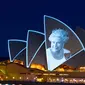 Layar Opera House, landmark ikonik Australia, menyala dengan potret Ratu Elizebeth II di Sydney, Jumat (9/9/2022). Ratu Elizabeth II meninggal dunia pada Kamis 8 September 2022 setelah 70 tahun bertahta. Ia mengembuskan napas terakhirnya di usia 96 tahun. (Photo by Robert WALLACE / AFP)