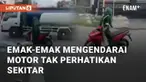 Seorang emak-emak terekam mengendarai motor sambil berkelok-kelok. Ia mengendarai motor tanpa memperhatikan kanan kiri