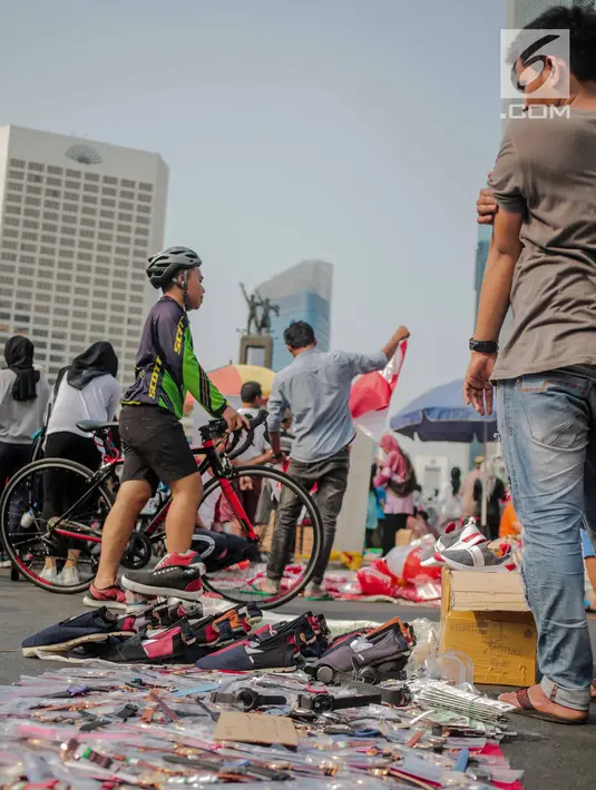 Warga melewati pedagang kaki lima (PKL) yang berjualan di kawasan car free day (CFD), Bundaran HI, Jakarta, Minggu (4/8/2019). Banyaknya PKL yang berjualan tidak pada tempatnya membuat semrawut dan mengganggu aktivitas olahraga. (Liputan6.com/Faizal Fanani)