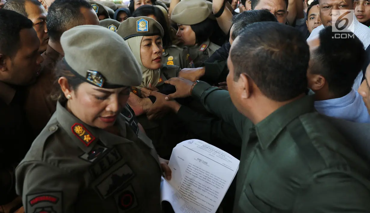 Ibu-ibu personel Satpol PP bersitegang dengan petugas keamanan di depan Hotel Alexis, Jakarta, Kamis (29/3). Pemprov DKI Jakarta resmi menutup operasi Hotel Alexis. (Liputan6.com/Immanuel Antonius)