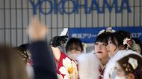 Perempuan Jepang berkimono yang merayakan ulang tahun ke-20 berswafoto sebelum berpartisipasi dalam upacara resmi, yang biasa disebut upacara Kedewasaan di Yokohama dekat Tokyo, Senin (9/1/2023). Jepang menurunkan usia dewasa dari 20 tahun menjadi 18 tahun pada 2022. (AP Photo/Eugene Hoshiko)