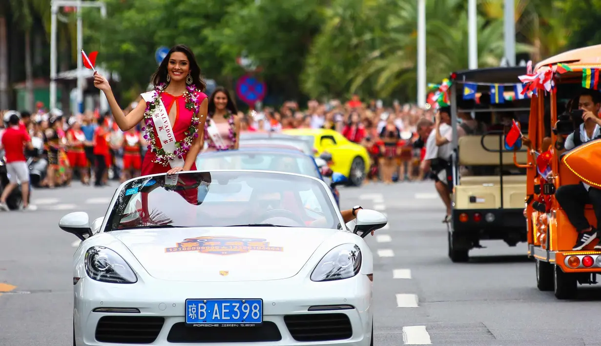 Kontestan Miss World dari El Savador tersenyum sambil membawa bendera China saat mengikuti pawai menggunakan supercar di Sanya, Provinsi Hainan, China, (7/11). Pawai ini membuka kontes kecantikan Miss World ke-67. (AFP Photo/Str/China Out)