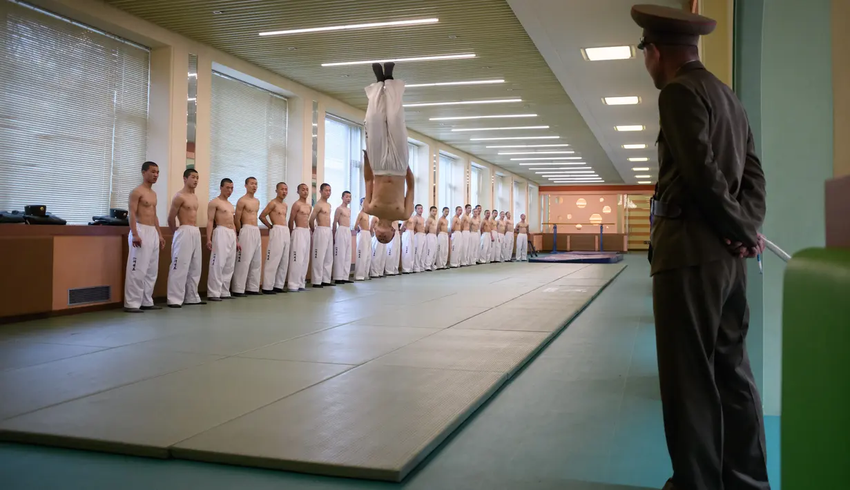 Siswa  melakukan demonstrasi taekwondo di Sekolah Revolusioner Mangyongdae, Korea Utara, 10 April 2018.   Setelah lulus, mereka akan masuk militer dan mengabdi sebagai anggota militer yang merupakan bagian penting di Korut. (ED JONES/AFP)