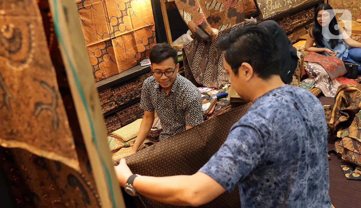 Pengunjung memilih koleksi batik yang dipamerkan pada Interior and Craft (ICRA) Exhibition 2019 yang dihelat di Hall A Jakarta Convention Center (JCC), Senayan, Jakarta, Minggu (6/10/2019). Ratusan motif batik dari berbagai daerah dipamerkan pada ajang ini. (Liputan6.com/Helmi Fithriansyah)