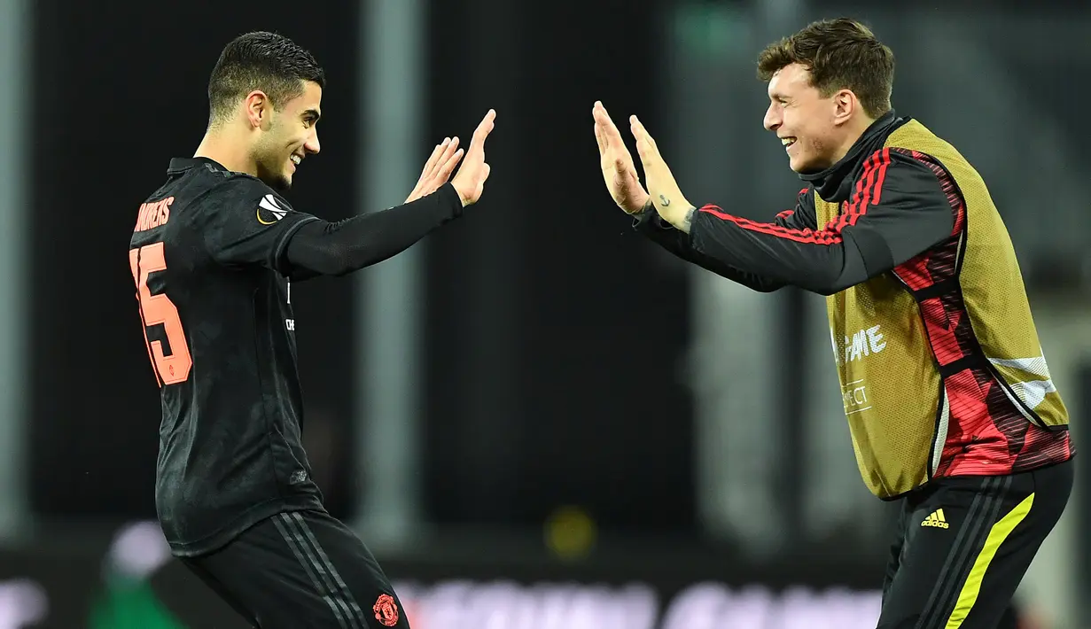 Pemain Manchester United (MU) Andreas Pereira (kiri) merayakan golnya ke gawang LASK Linz pada leg pertama babak 16 besar Liga Europa di Linz, Austria, Kamis (12/3/2020). MU menang 5-0. (JOE KLAMAR/AFP)