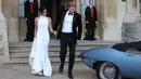 Pangeran Harry dan istrinya Meghan Markle bersiap meninggalkan Kastil Windsor dengan menggunakan mobil listrik Jaguar Classic E-Type Concept Zero menuju acara resepsi dekat Frogmore House (19/5). (AFP Photo/Pool/Steve Parsons)