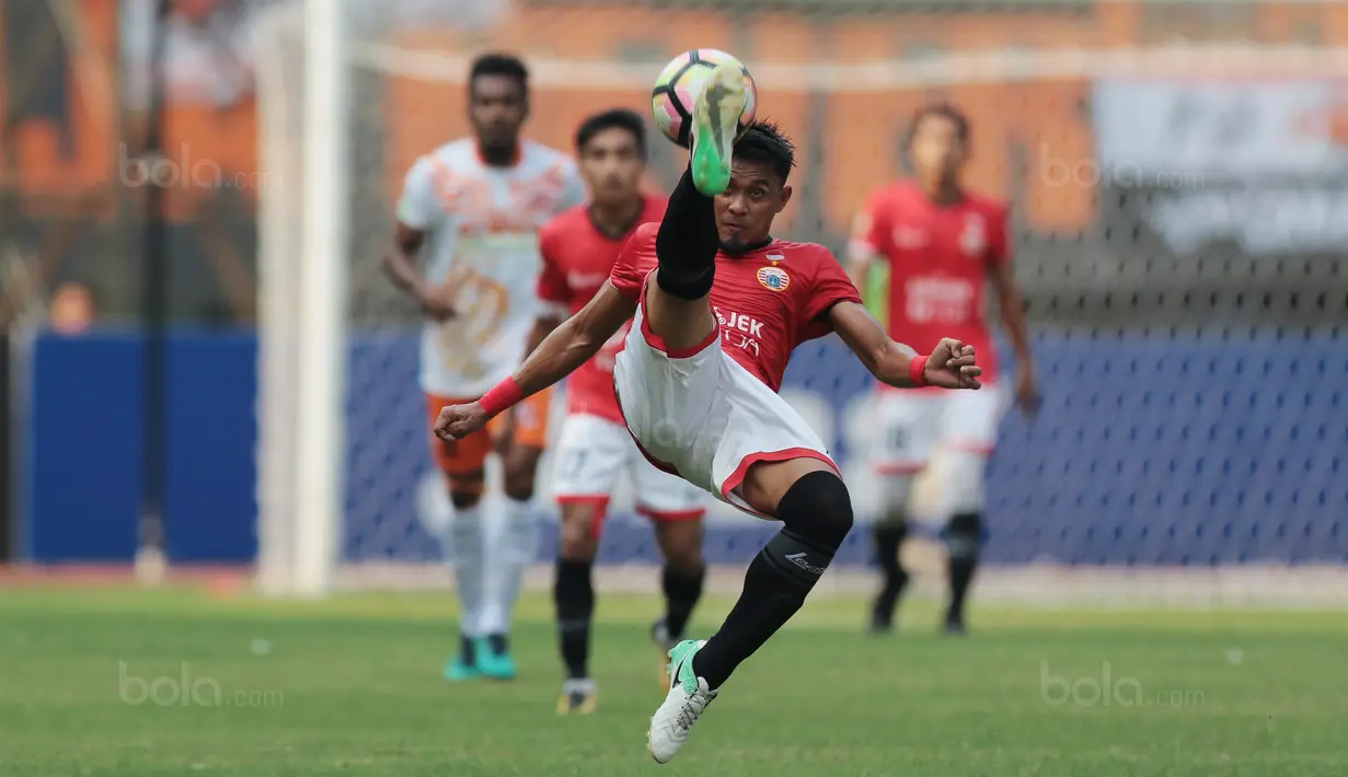 Aksi pemain Persija Jakarta, Maman Abdurahman membuang bola dari kejaran pemain Perseru Serui pada lanjutan Liga 1 2017 di Stadion Patriot Bekasi, Selasa (19/9/2017). Persija menang 1-0. (Bola.com/Nicklas Hanoatubun)