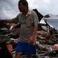 Seorang pria dan wanita mencari barang-barang di mana rumah mereka berdiri sebelum gempa dan tsunami di desa Wani, Palu, Kamis (4/10). Gempa bumi berkekuatan 7,4 skala richter melanda Palu dan Donggala pada 28 September 2018 lalu. (AP/Dita Alangkara)