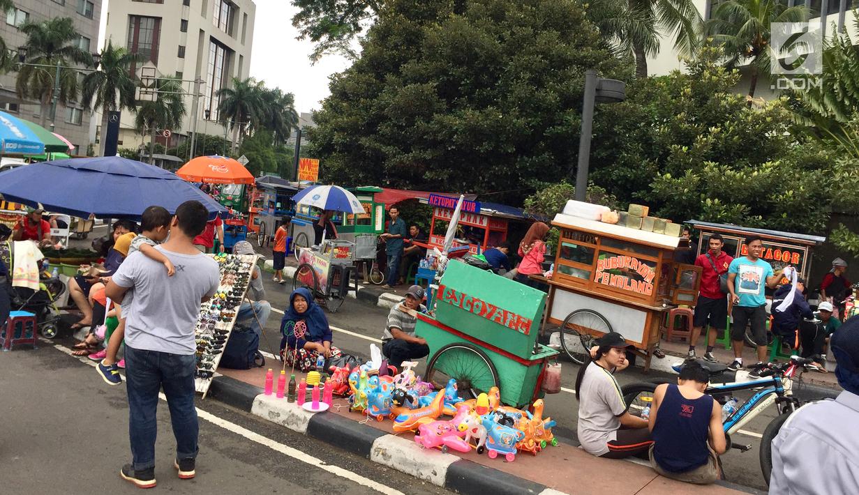 Suasana CFD yang berlangsung di kawasan Jalan Jenderal Sudirman-MH Thamrin, Jakarta, Minggu (11/2). Dishub mengeluarkan imbauan berupa spanduk karena para PKL memakan bahu jalan dan mengganggu aktivitas pengunjung CFD. (Liputan6.com/Immanuel Antonius)