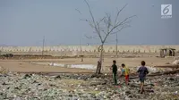Anak-anak bermain di permukiman kumuh yang berdiri di atas tumpukan sampah di Kampung Bengek, Penjaringan, Jakarta Utara, Selasa (3/9/2019). Permukiman kumuh tersebut berdiri di atas rawa yang membeku karena timbunan sampah plastik, kasur bekas hingga limbah rumah tangga (Liputan6.com/Faizal Fanani)