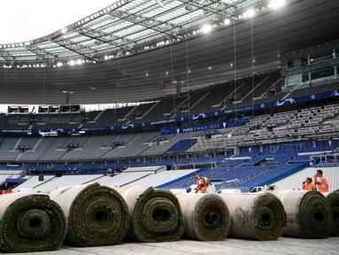 Sejumlah pekerja sedang memasang rumput hybrid baru di Stade de France, Saint-Denis, pada 24 Mei 2022 waktu setempat. Dalam waktu 48 jam, rumput baru yang ditanam di luar Barcelona, dipasang di Stade de France untuk pertandingan final Liga Champions antara Real Madrid dan Liverpool yang dijadwalkan berlangsung pada 28 Mei 2022. (AFP/Franck Fife)