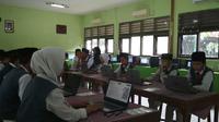 MTS N 2 Kota Cirebon memiliki cara tersendiri demi kelancaran pelaksanaan UNBK pertama mereka yakni dengan menggunakan modem dan tathering atau berbagi koneksi. Foto (Liputan6.com / Panji Prayitno)