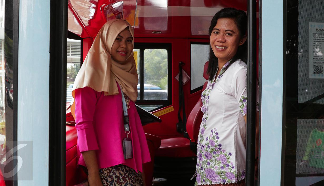 Petugas bus tingkat wisata TransJakarta mengenakan kebaya saat menjalankan tugasnya di Jakarta, Jumat (21/4). Dalam rangka Hari Kartini, semua pramudi perempuan bus pariwisata dan Transjakarta mengenakan kebaya. (Liputan6.com/Faizal Fanani)