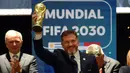 Presiden Paraguay, Alejandro Dominguez mengangkat replika trofi Piala Dunia saat penunjukkan Argentina, Paraguay, dan Uruguay sebagai negara tuan rumah Piala Dunia FIFA 2030 selama Kongres virtual FIFA di Luque, Paraguay pada 11 Desember 2024. (AFP/Daniel Duarte)