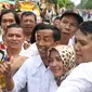 Warga berebut foto bersama seorang pria berwajah mirip Presiden Joko Widodo (Jokowi) di sekitar lokasi akad nikah Kahiyang Ayu dengan Bobby Nasution, Solo, Rabu (8/11). Pria bernama David Indrajaya itu datang dari Bandung. (Liputan6.com/Angga Yuniar)