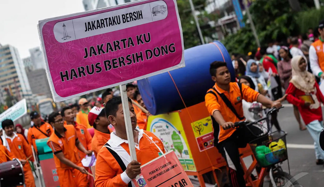 Seorang petugas Dinas Kebersihan Jakarta membawa spanduk bertuliskan 'Jakartaku Harus Bersih Dong' dalam aksi damai di Bundaran HI, Minggu (28/12/2014). (Liputan6.com/Faizal Fanani)