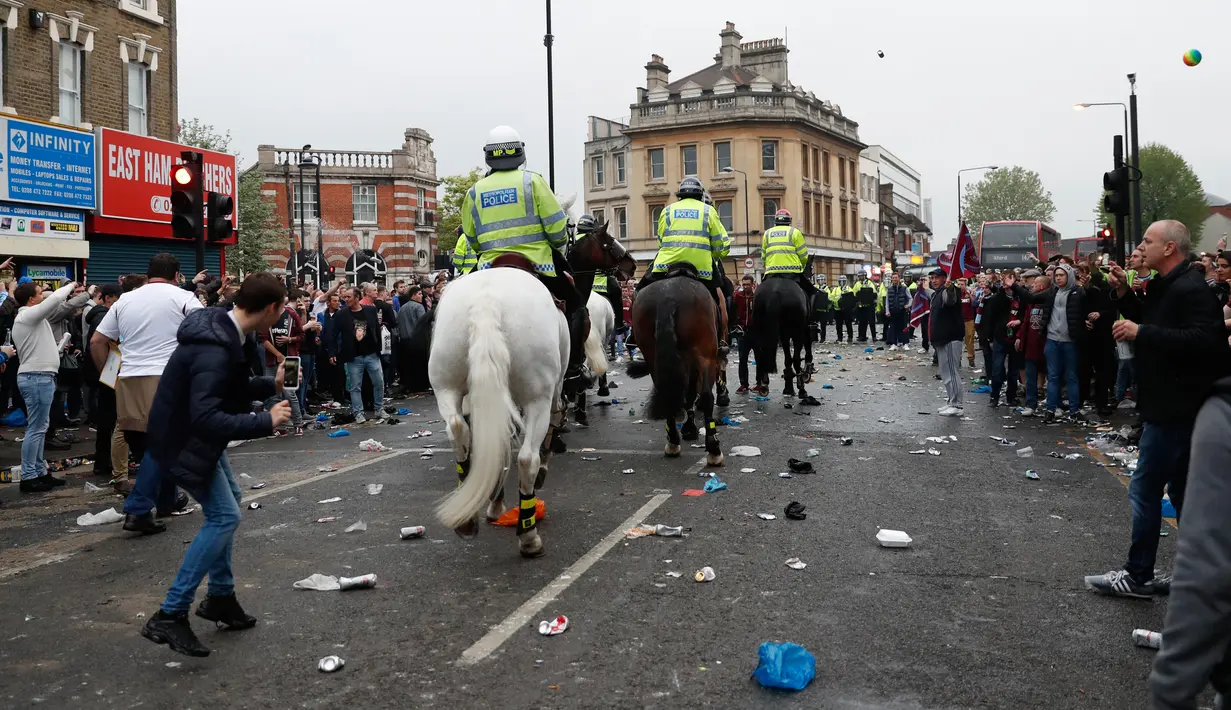Polisi berkuda dikerahkan membubarkan suporter West Ham United yang menyerang bus skuat Manchester United di depan Stadion Boleyn Ground, London, Selasa (10/5). Sejumlah hooligan West Ham memblokir jalan dan menyerang bus tim tamu. (Reuters/Eddie Keogh)